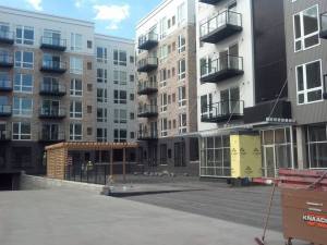 Apartment building courtyard with barbecue and sheltered areas being built.